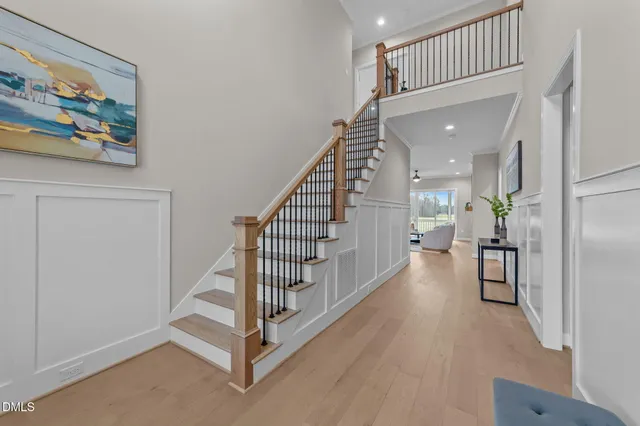 a hallway with painting on the wall and a potted plant