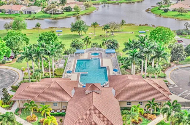 an aerial view of a house with garden space and a lake view
