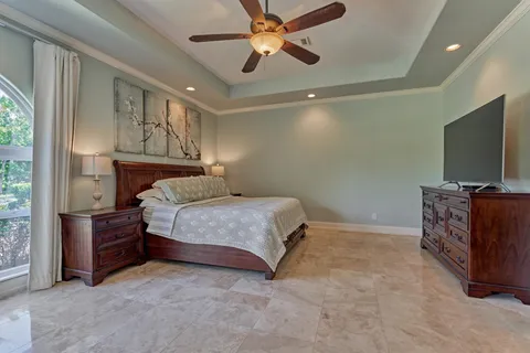 a bedroom with a bed and a flat tv screen on dresser