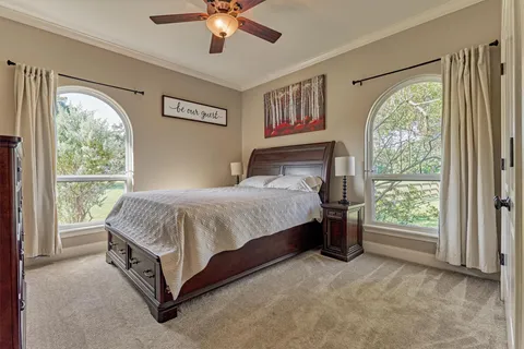 a spacious bedroom with a large bed and a chandelier