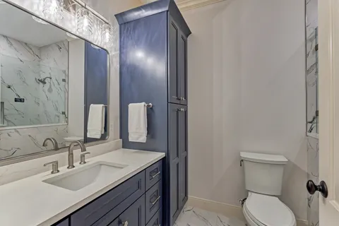 a bathroom with a toilet sink and mirror