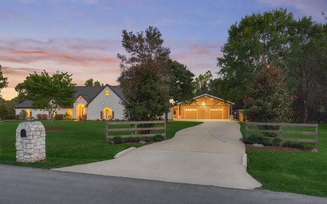 a front view of a house with a yard and trees
