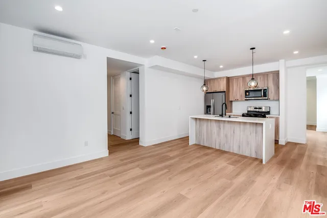 a kitchen with a refrigerator and a stove top oven
