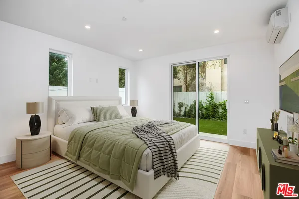 a spacious bedroom with a bed and a large window