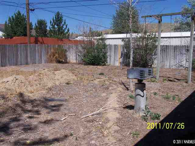 17255 Waxwing Street Reno, NV 89508 - Photo 11 of 13 a backyard of a house with large trees and wooden fence