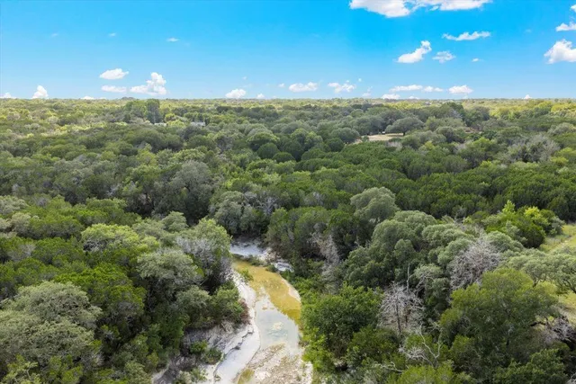 a view of a field with trees in the background
