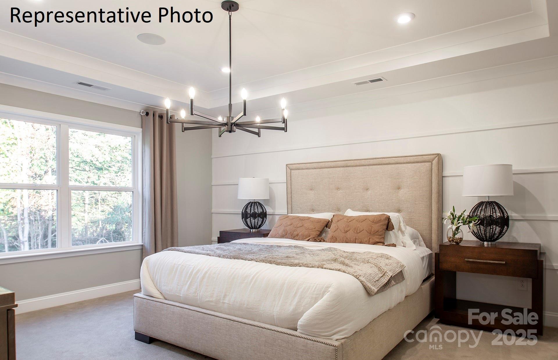 4707 Formation Court, Unit 49 Lancaster, SC 29720 - Photo 21 of 21 a bedroom with a bed a chandelier and a window