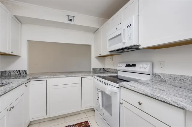 a kitchen with granite countertop a sink and cabinets