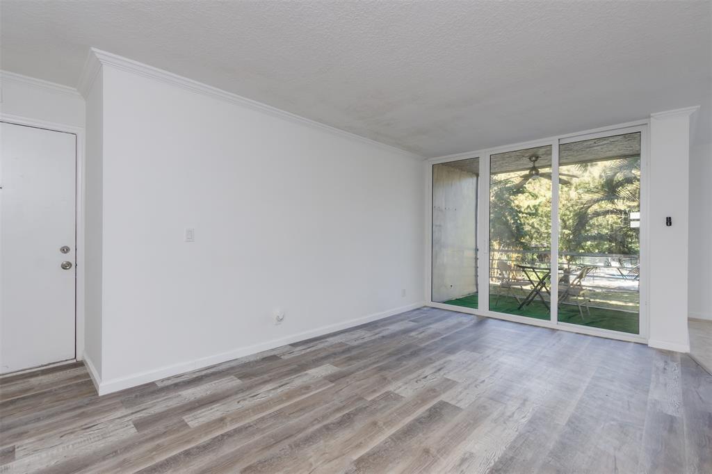 9410 Live Oak Place, Unit 203 Davie, FL 33324 - Photo 5 of 40 a view of an empty room with wooden floor and a window