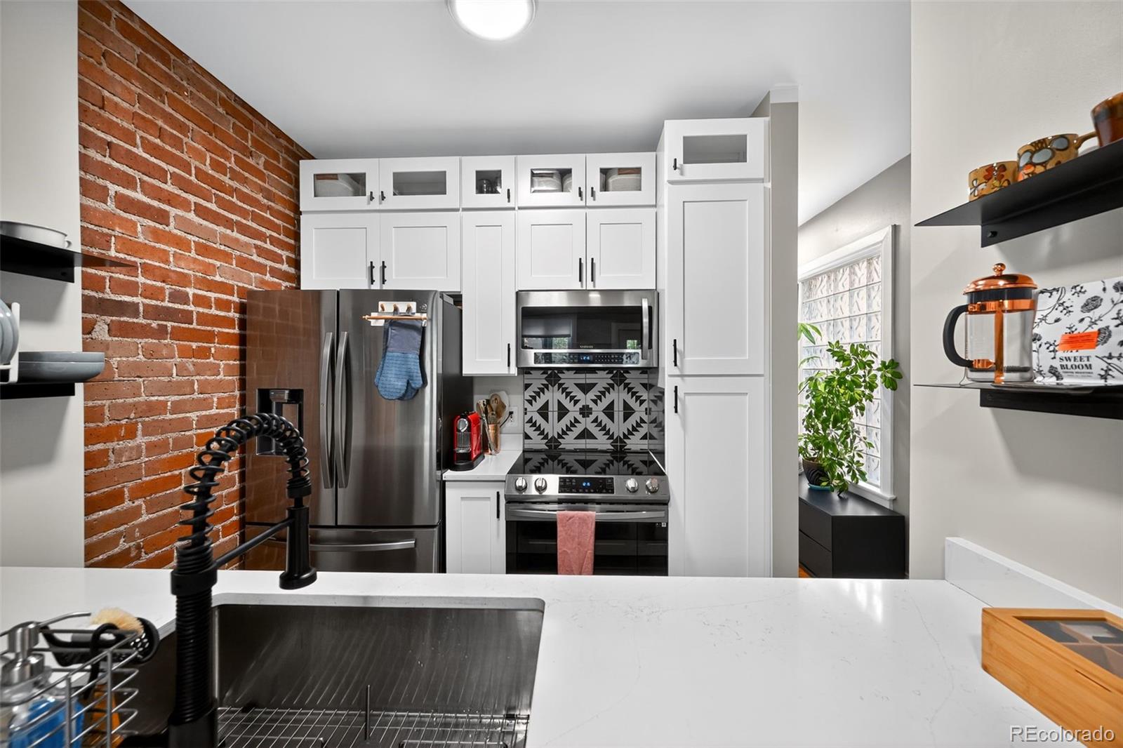726 Fox Street Denver, CO 80204 - Photo 11 of 33 a kitchen with stainless steel appliances kitchen island granite countertop a refrigerator and stove