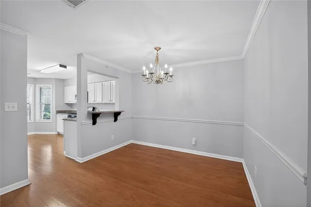 a view of a kitchen with wooden floor and a chandelier