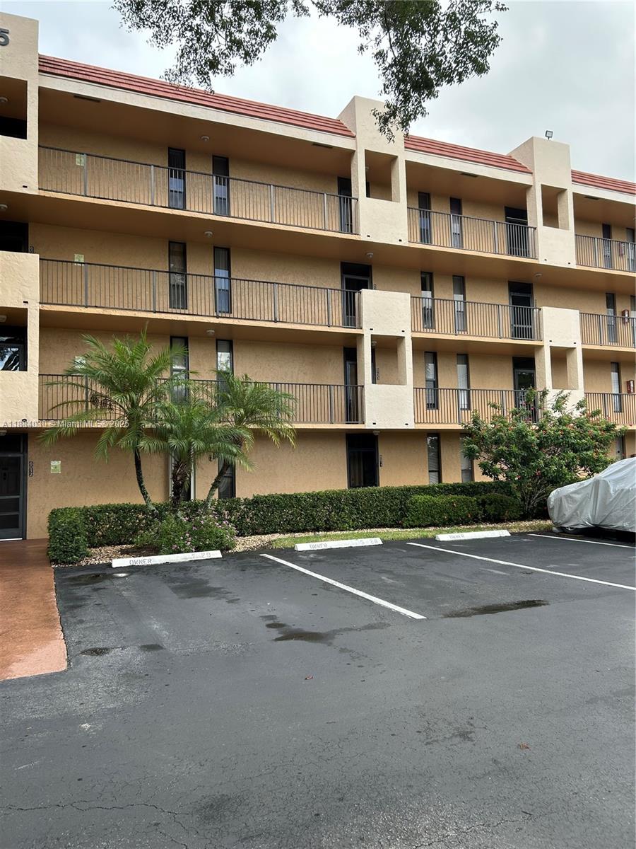 6011 Coral Lake Drive, Unit 111 Margate, FL 33063 - Photo 1 of 5 a front view of a building with a garden and parking space