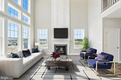 a living room with furniture a fireplace and a floor to ceiling window