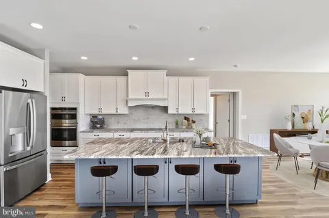 a kitchen with a kitchen island white cabinets and stainless steel appliances
