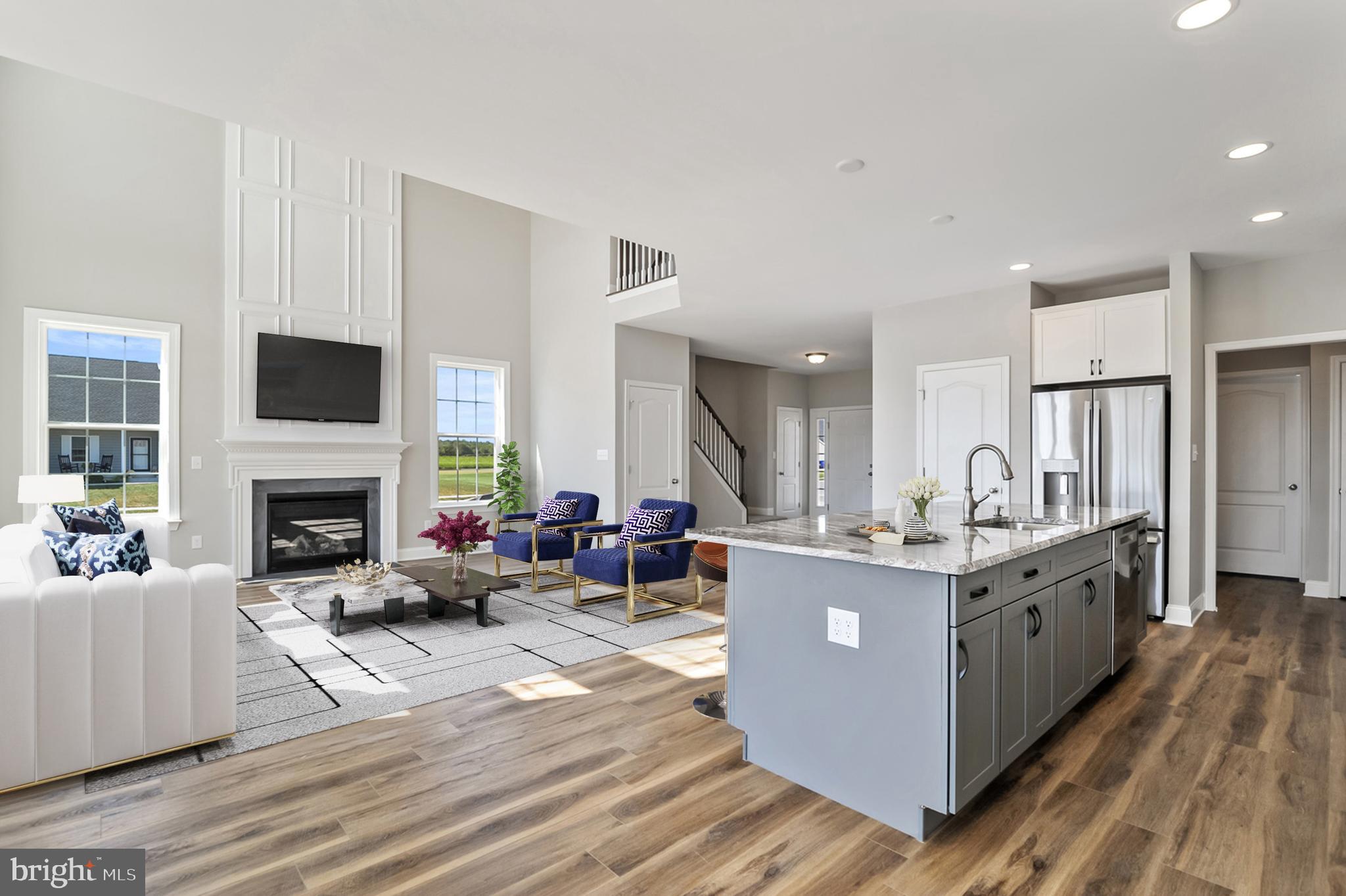 296 Robbins Road, Unit GEO Frederica, DE 19946 - Photo 7 of 16 a living room with furniture a fireplace and a dining table with wooden floor