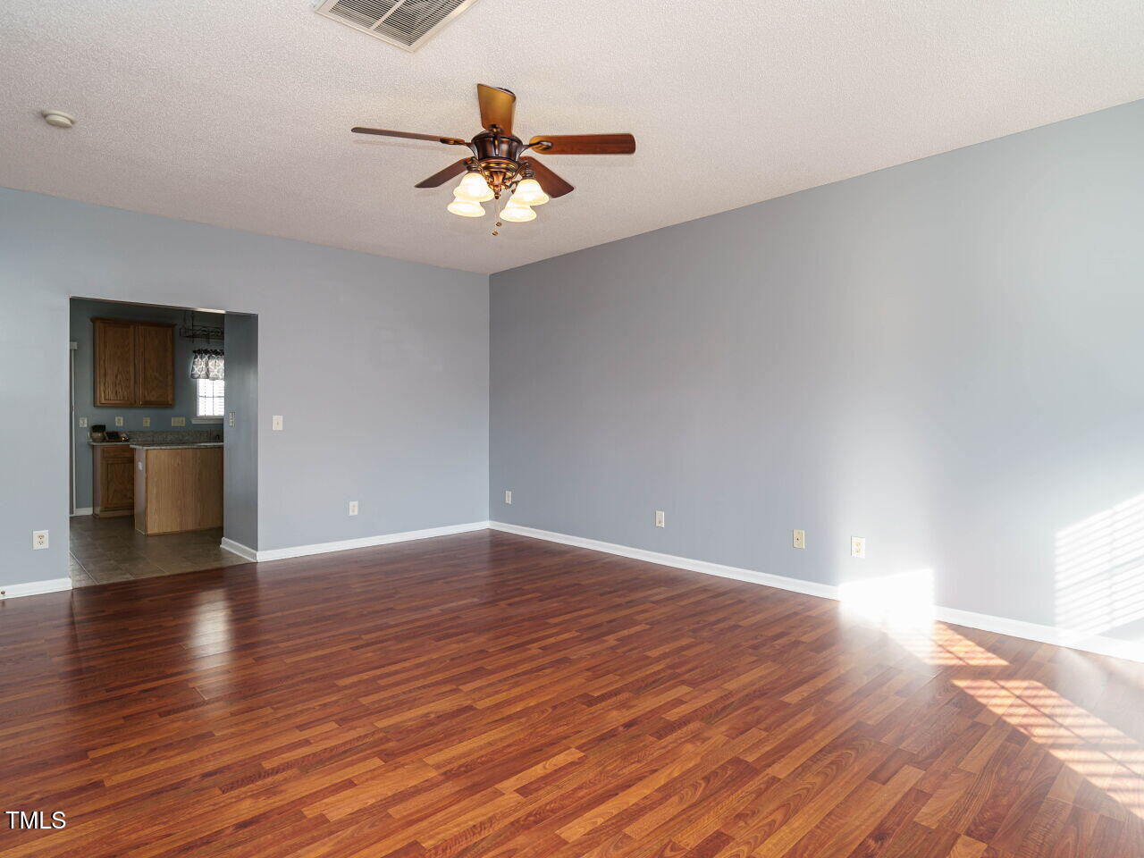 125 Watertree Lane Apex, NC 27502 - Photo 10 of 32 a view of an empty room with wooden floor and a ceiling fan