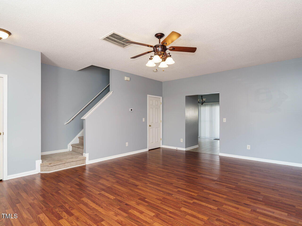 125 Watertree Lane Apex, NC 27502 - Photo 3 of 32 a view of an empty room with wooden floor and a ceiling fan