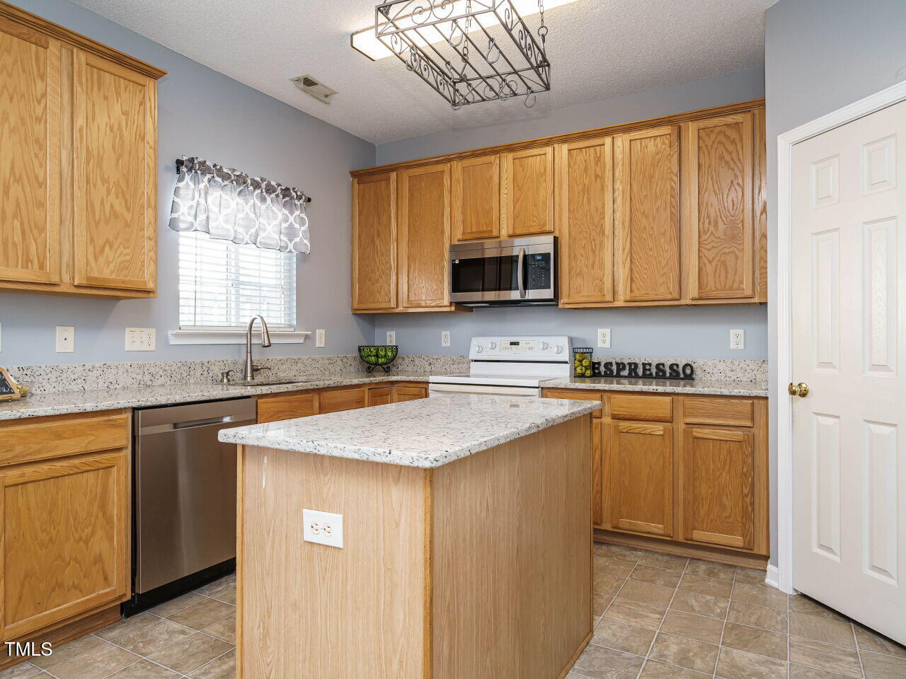 125 Watertree Lane Apex, NC 27502 - Photo 4 of 32 a kitchen with stainless steel appliances granite countertop a sink a stove a refrigerator a washer dryer and a cabinets