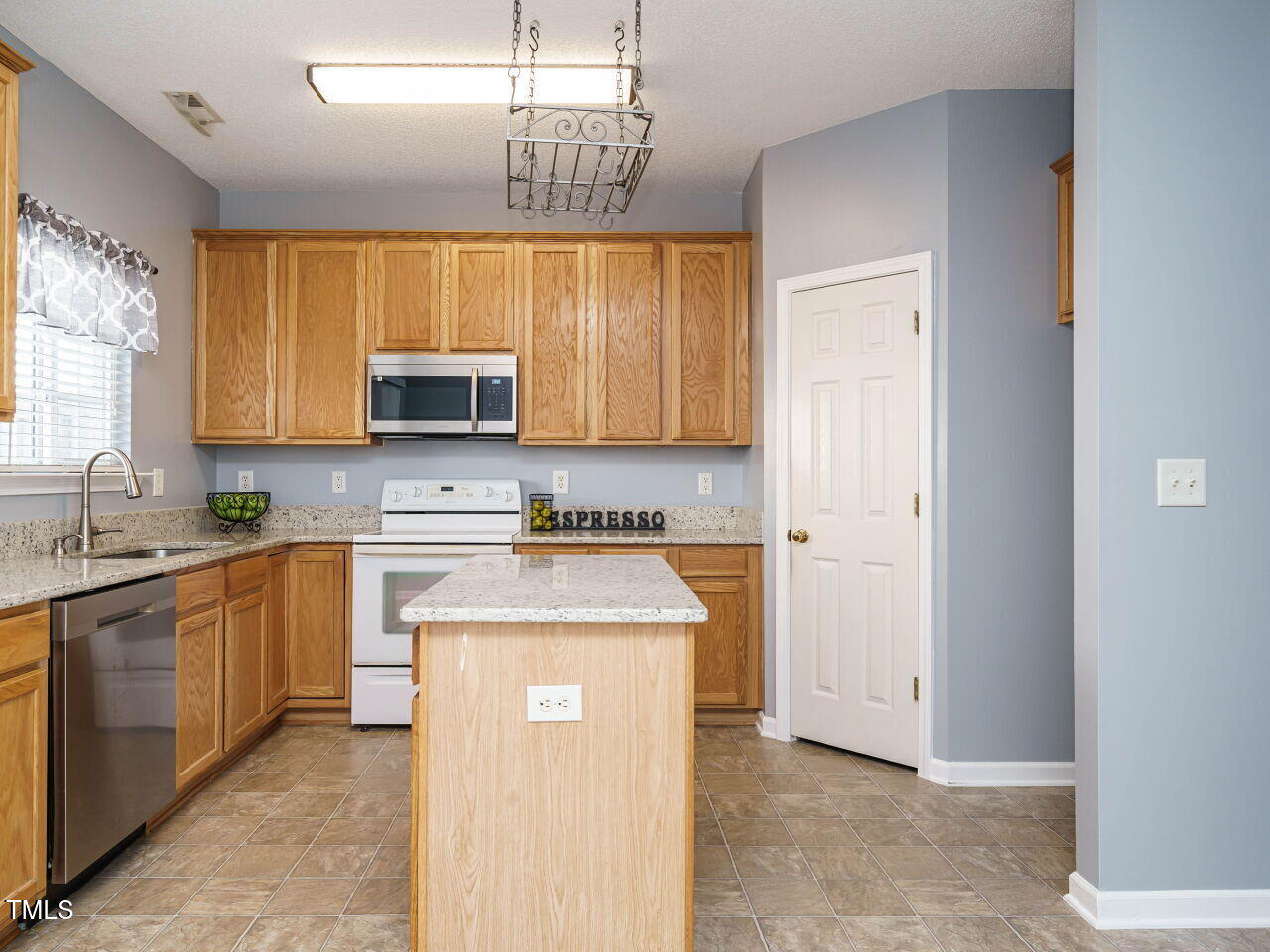 125 Watertree Lane Apex, NC 27502 - Photo 5 of 32 a kitchen with stainless steel appliances granite countertop a sink stove and refrigerator