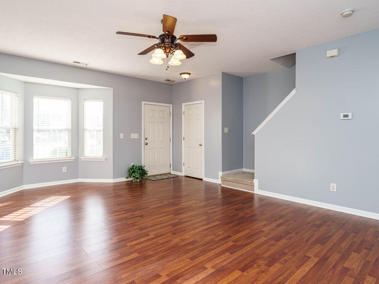 125 Watertree Lane Apex, NC 27502 - Photo 8 of 32 a view of an empty room with wooden floor and a window