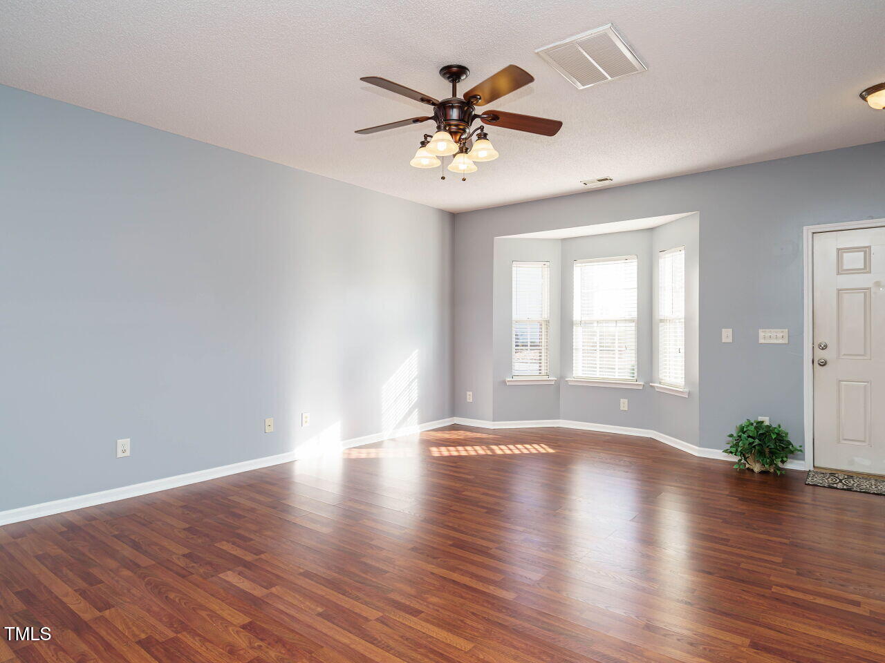 125 Watertree Lane Apex, NC 27502 - Photo 9 of 32 a view of an empty room with wooden floor and a window