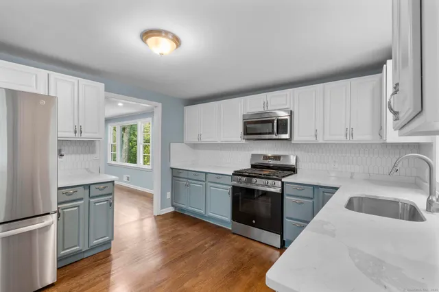 a kitchen with granite countertop a stove top oven and refrigerator