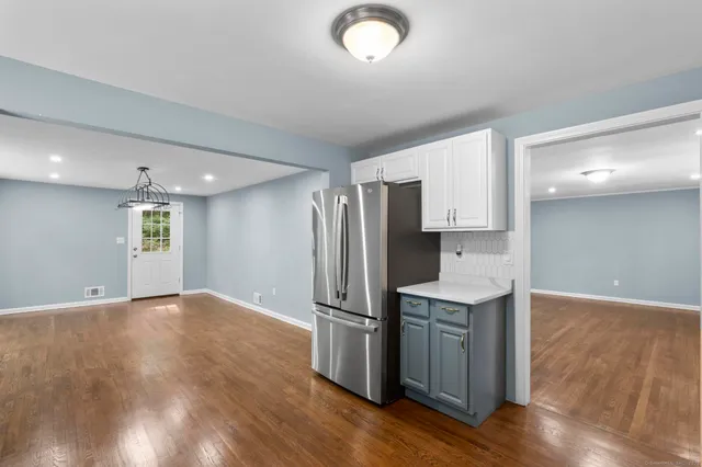 a kitchen with stainless steel appliances granite countertop a refrigerator a stove and a sink