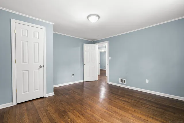 a view of an empty room with wooden floor