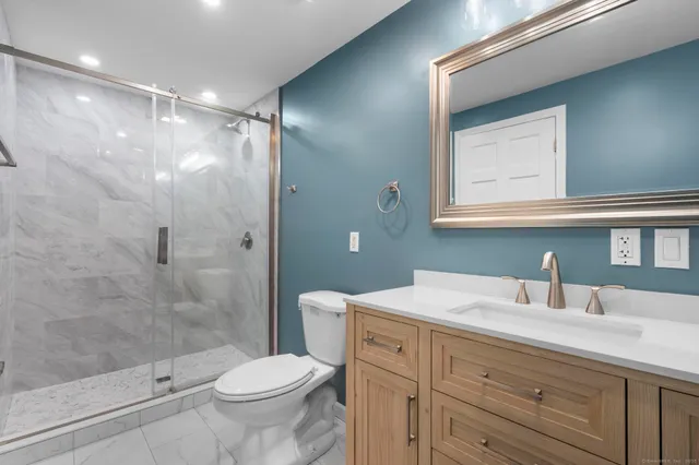 a bathroom with a sink a toilet and shower