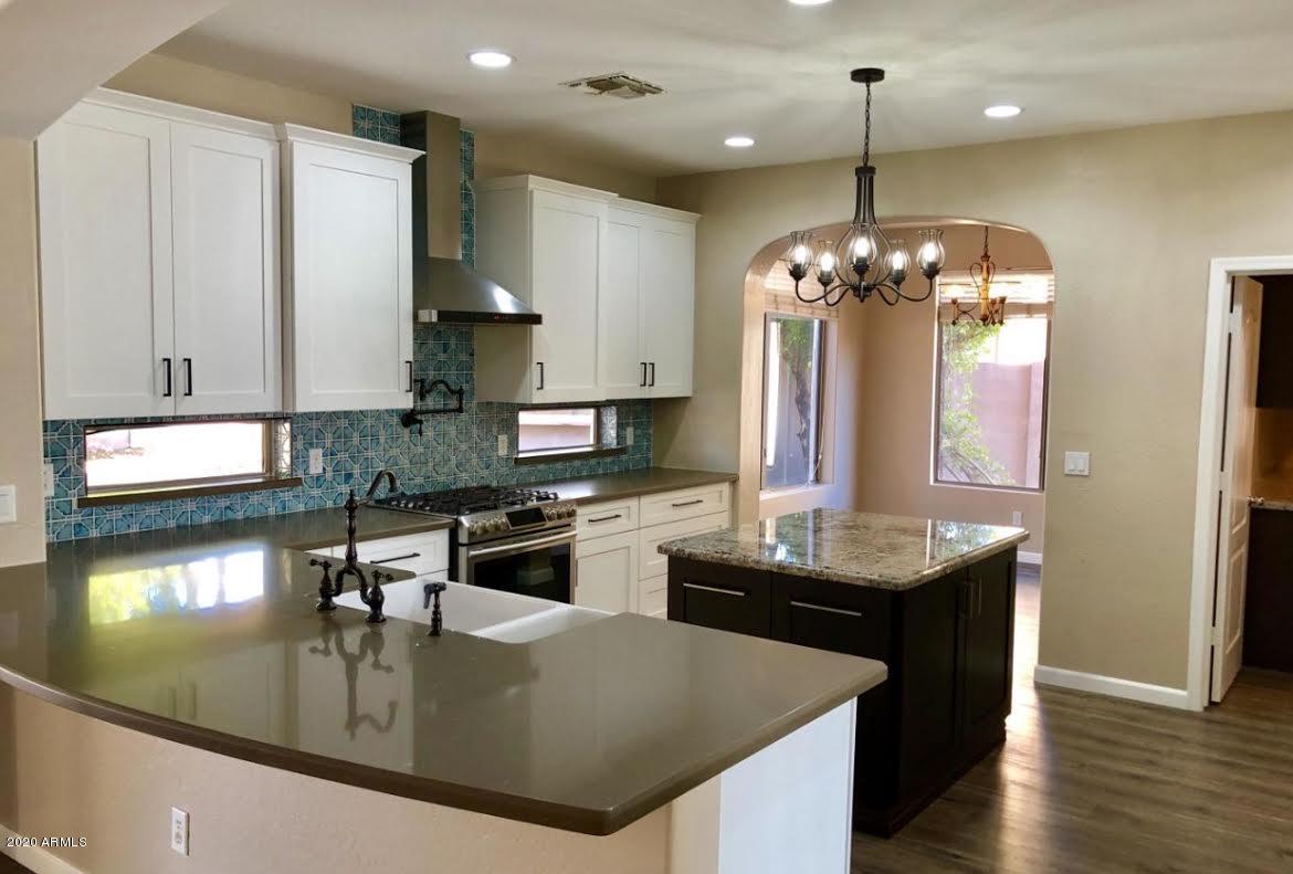 140 West Cardinal Way Chandler, AZ 85286 - Photo 2 of 44 a kitchen with stainless steel appliances granite countertop a sink a stove and a wooden floors