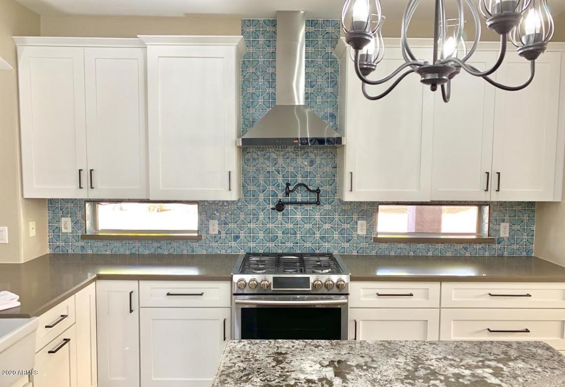 140 West Cardinal Way Chandler, AZ 85286 - Photo 4 of 44 a kitchen with stainless steel appliances granite countertop a sink a stove and cabinets