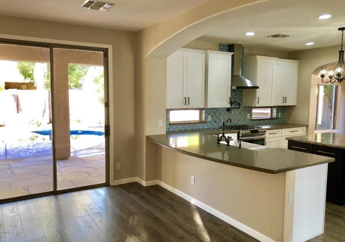 140 West Cardinal Way Chandler, AZ 85286 - Photo 9 of 44 a kitchen with stainless steel appliances granite countertop a sink a stove a refrigerator a microwave and wooden cabinets