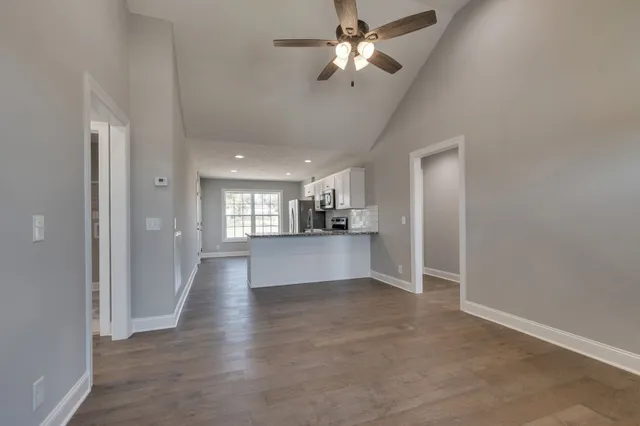 a view of an empty room and kitchen view