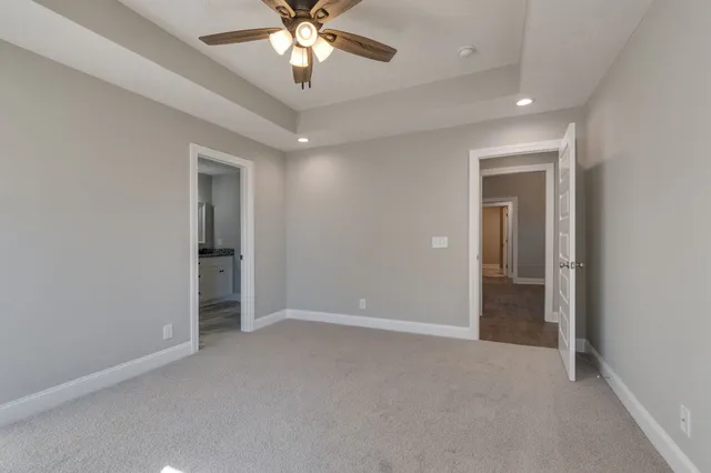 a view of an empty room with a chandelier fan