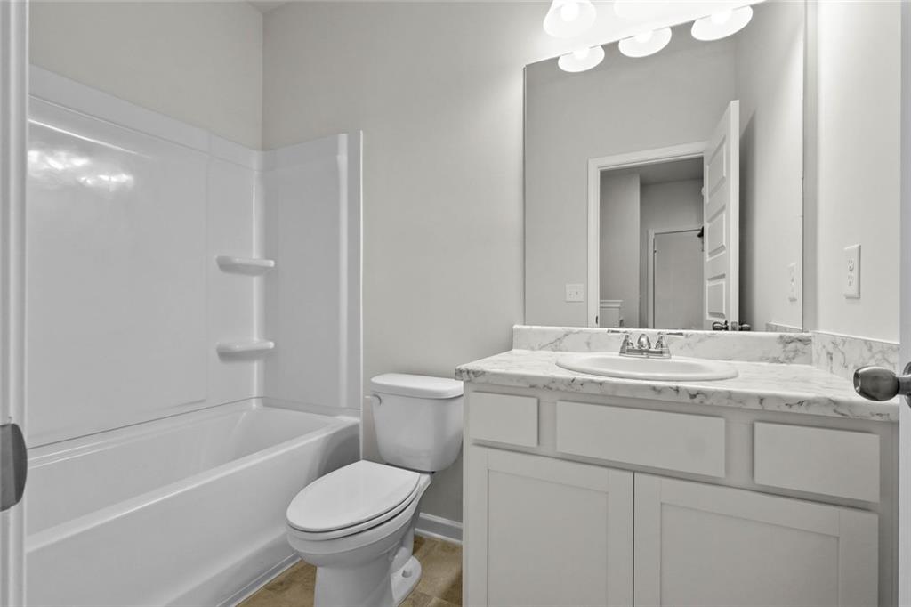 6 Cavalier Court Rome, GA 30165 - Photo 27 of 30 a bathroom with a granite countertop toilet a sink and a mirror