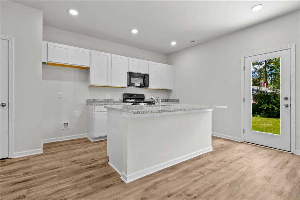 6 Cavalier Court Rome, GA 30165 - Photo 6 of 30 a kitchen with stainless steel appliances granite countertop a stove a sink and a microwave