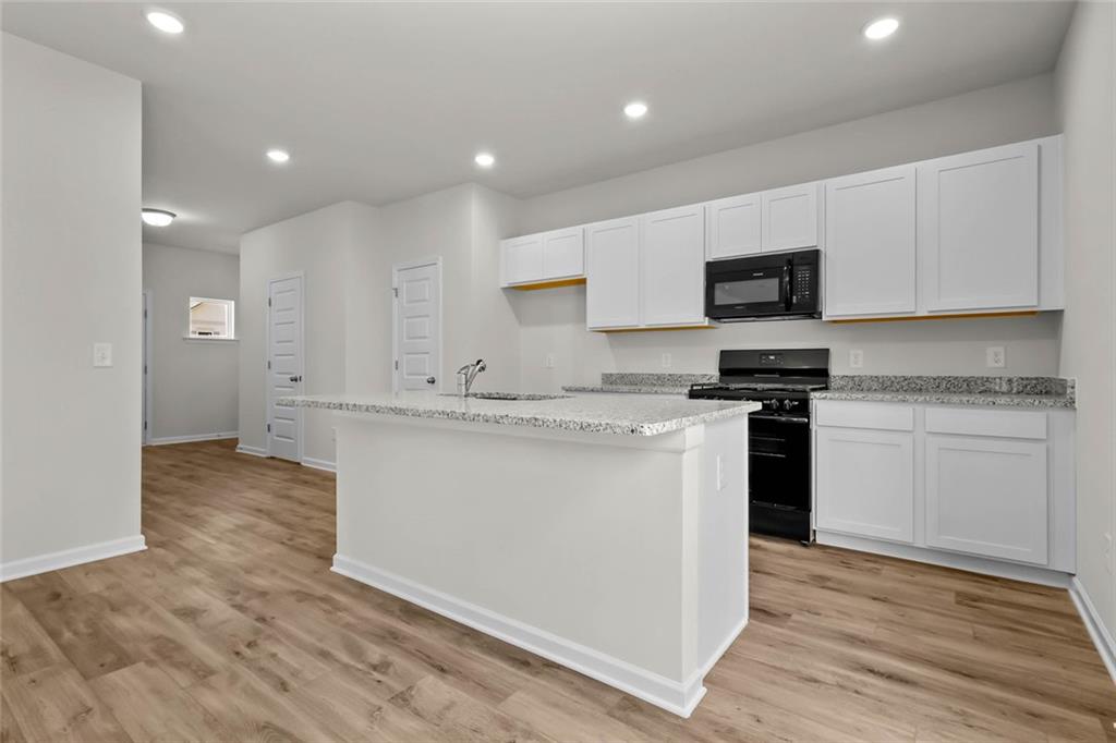 6 Cavalier Court Rome, GA 30165 - Photo 8 of 30 a kitchen with kitchen island a sink stainless steel appliances and cabinets