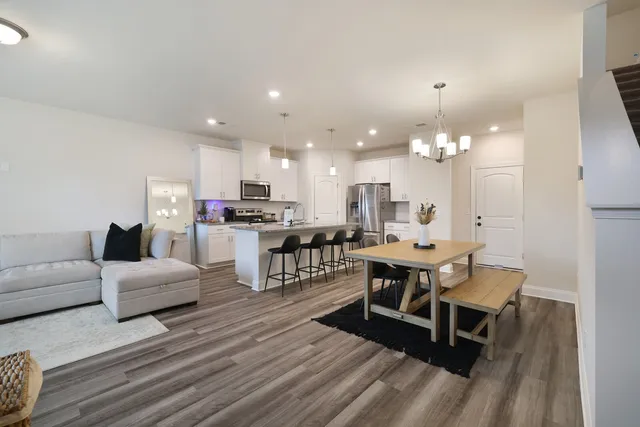 a living room with lots of furniture and kitchen view