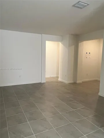 an empty room with a white wall and a window