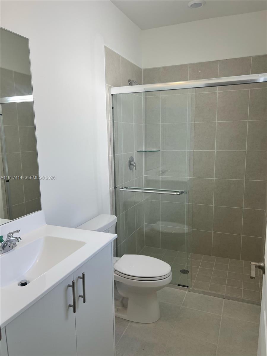 2422 Southeast 30th Street Homestead, FL 33035 - Photo 18 of 36 a bathroom with a shower a sink a toilet and mirror