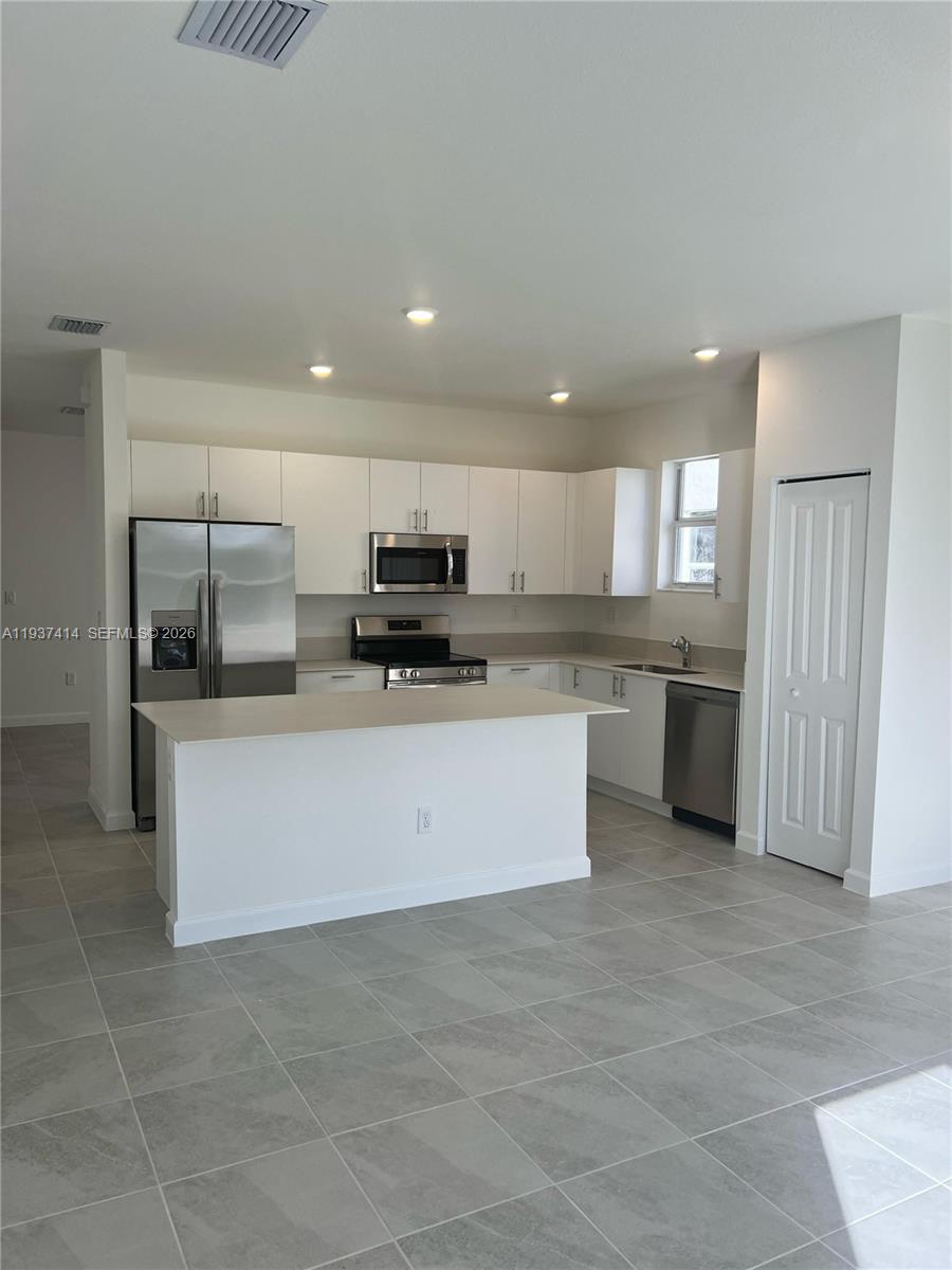 2422 Southeast 30th Street Homestead, FL 33035 - Photo 9 of 36 a large kitchen with a large counter top stainless steel appliances and cabinets