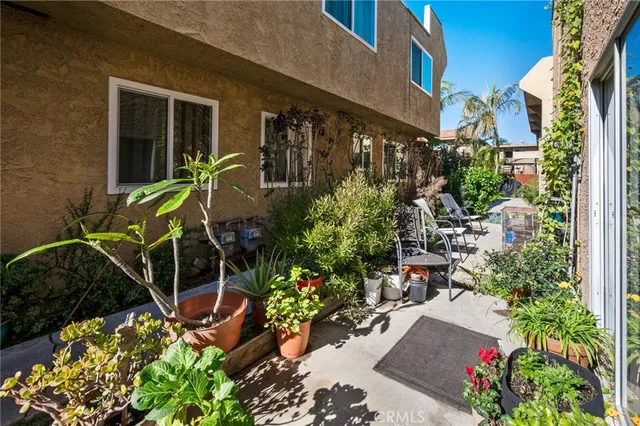 a view of a patio with table and chairs and potted plants