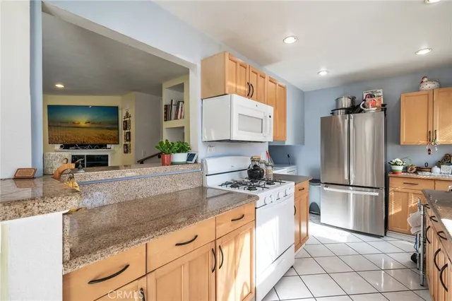 a kitchen with stainless steel appliances granite countertop a refrigerator sink and stove