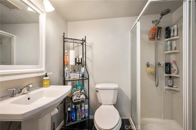 a bathroom with a sink a toilet and shower