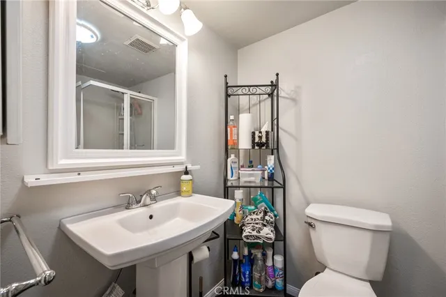 a bathroom with a sink a toilet and a mirror