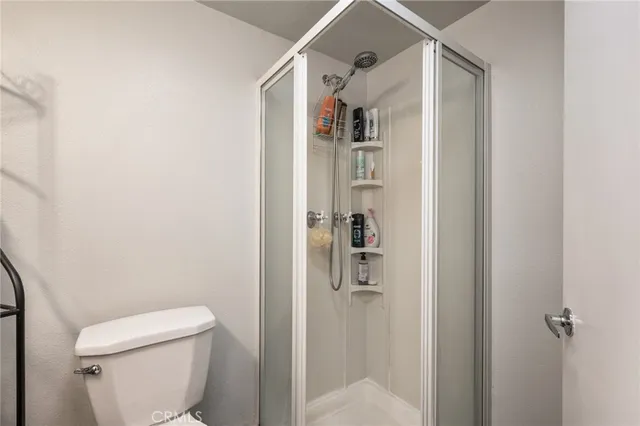 a white toilet sitting next to a shower