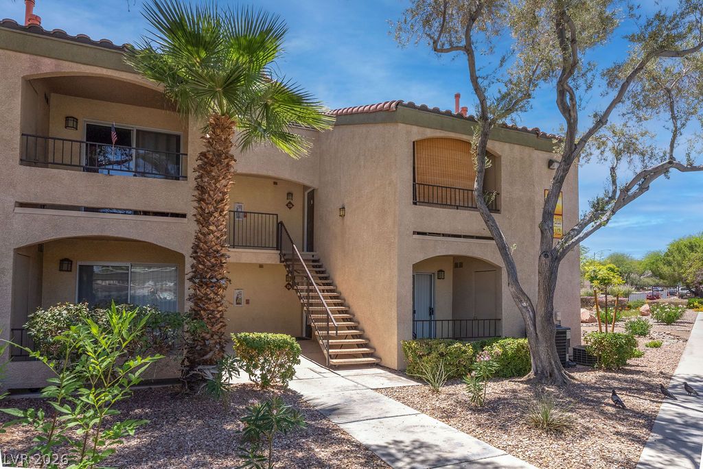 7885 West Flamingo Road, Unit 1016 Las Vegas, NV 89147 - Photo 23 of 24 Multi-level residential building showcasing balconies and inviting walkways amidst desert-friendly landscaping.