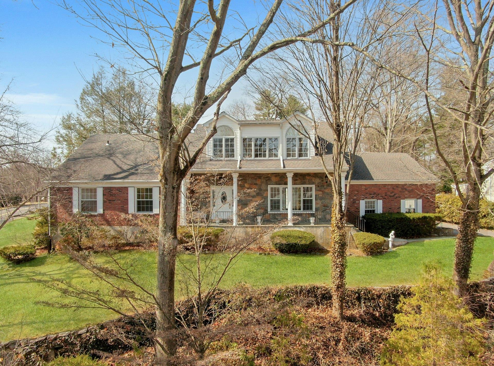 View of front of home with brick siding and a front lawn