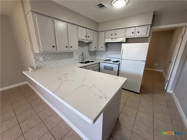 a kitchen with stainless steel appliances a refrigerator sink and cabinets