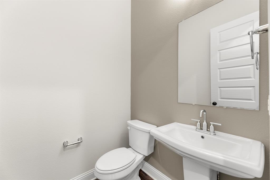 3916 Keya Drive Prosper, TX 75078 - Photo 14 of 28 a white toilet sitting next to a bathroom sink